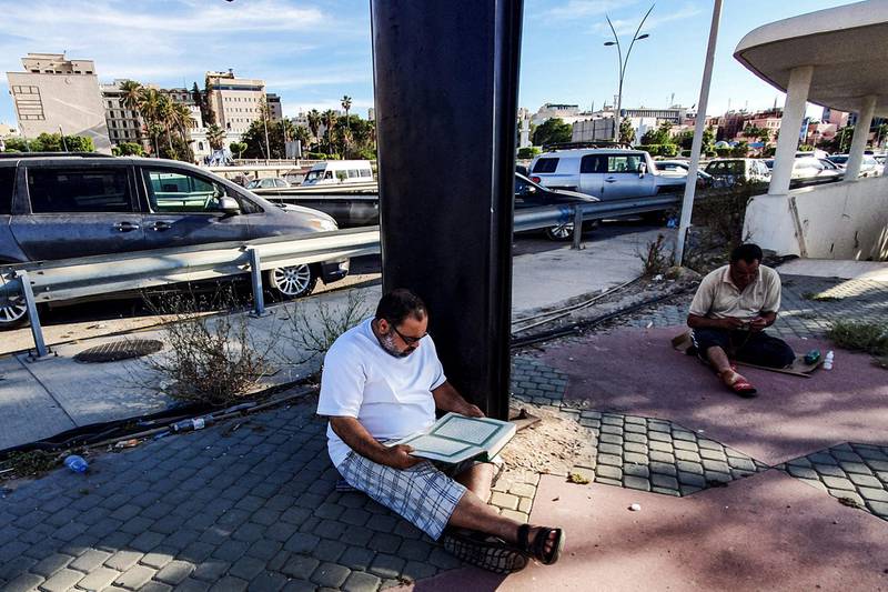 Muslim men read the Quran by the waterfront in the Libyan capital Tripoli.    AFP