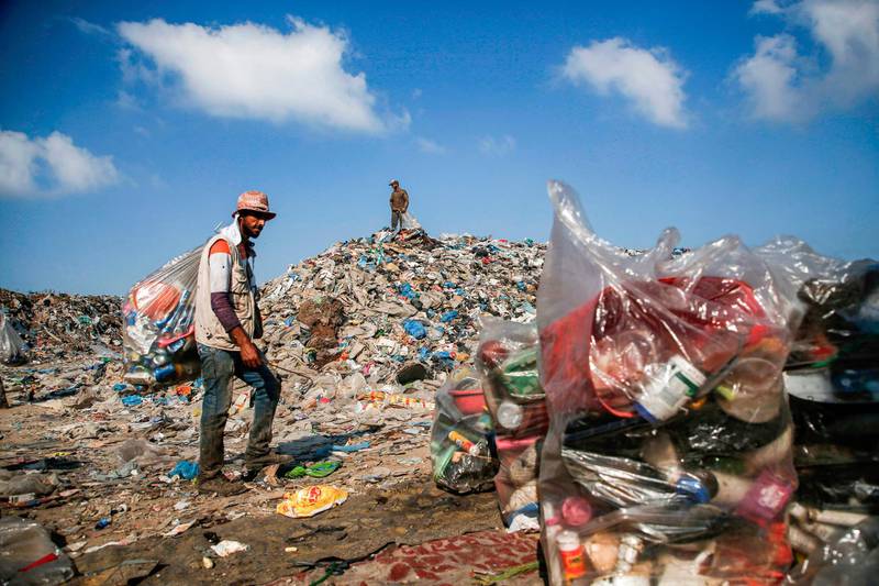 Palestinian garbage collectors sort through trash at a landfill in Gaza City.  AFP