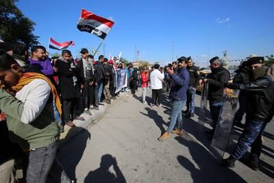 Iraqi policemen stand guard as protesters take part in an anti-government protest in Nisour Square, Baghdad, on January 20. EPA