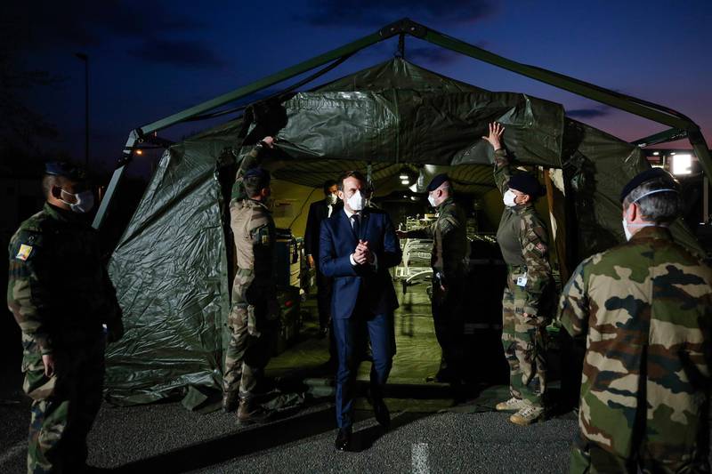 French President Emmanuel Macron wears a face mask during his visit at the military field hospital in Mulhouse, eastern France.  AP