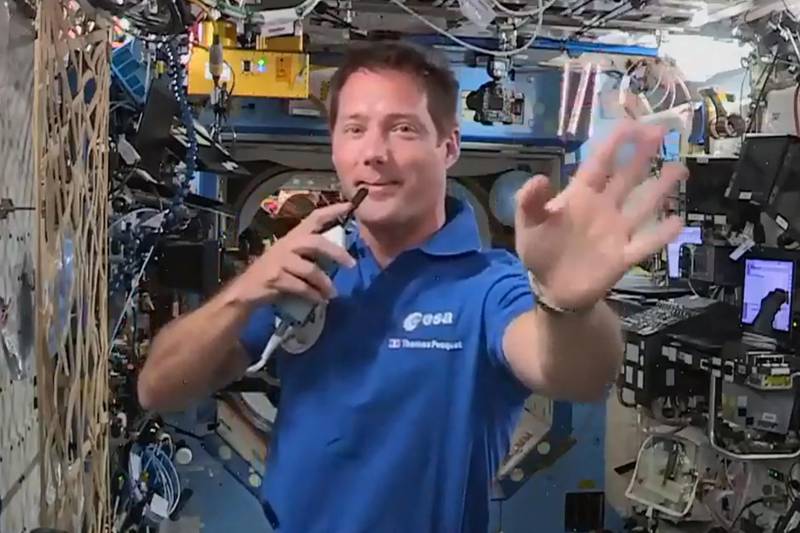 European Space Agency French astronaut Thomas Pesquet waves from the International Space Station at the end of a question and answer session with media representatives in Paris.  AFP