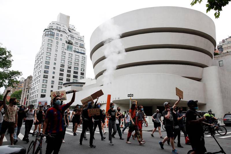 Protestors hold up signs while demonstrating in the street past The Guggenheim Museum in New York.  EPA