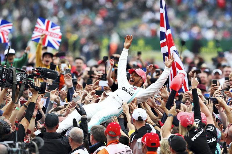 NORTHAMPTON, ENGLAND - JULY 14: Race winner Lewis Hamilton of Great Britain and Mercedes GP celebrates with fans after the F1 Grand Prix of Great Britain at Silverstone on July 14, 2019 in Northampton, England. (Photo by Mark Thompson/Getty Images)