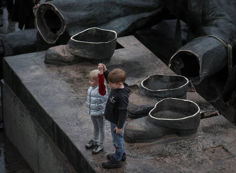 Children depict a Soviet monument to friendship between Ukrainian and Russian nations after its demolition, amid Russia's invasion of Ukraine, in central Kyiv. Reuters