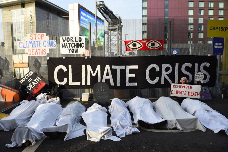 Activists from the climate change group Extinction Rebellion pretend to be dead under white sheets as they hold a 'Remember climate death' sit-in on the sidelines of Cop26. AFP