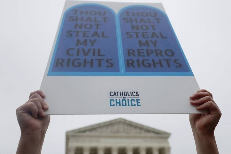 A Catholic pro-choice demonstrator holds a sign during a protest outside the US Supreme Court. Reuters