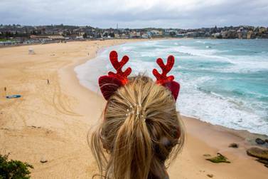SYDNEY, AUSTRALIA - DECEMBER 25: A woman wearing antlers looks at Bondi Beach on December 25, 2020 in Sydney, Australia. December is one of the hottest months of the year across Australia, with Christmas Day traditionally involving a trip to the beach and celebrations outdoors. (Photo by Jenny Evans/Getty Images)