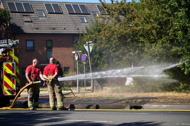 London Fire Brigade dealing with the aftermath of a grass fire in Rainham, east London. PA