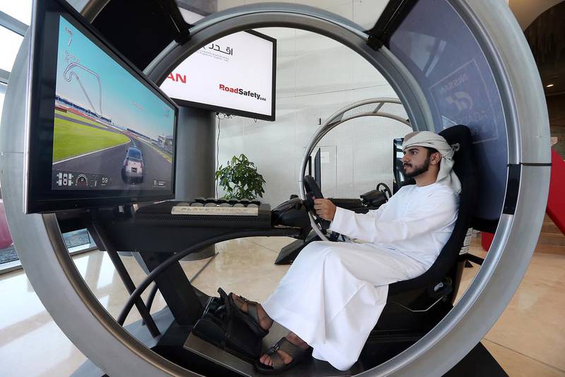 A student tests his driving skills at the launch of the latest safe driving campaign at Zayed University in Abu Dhabi. Satish Kumar / The National