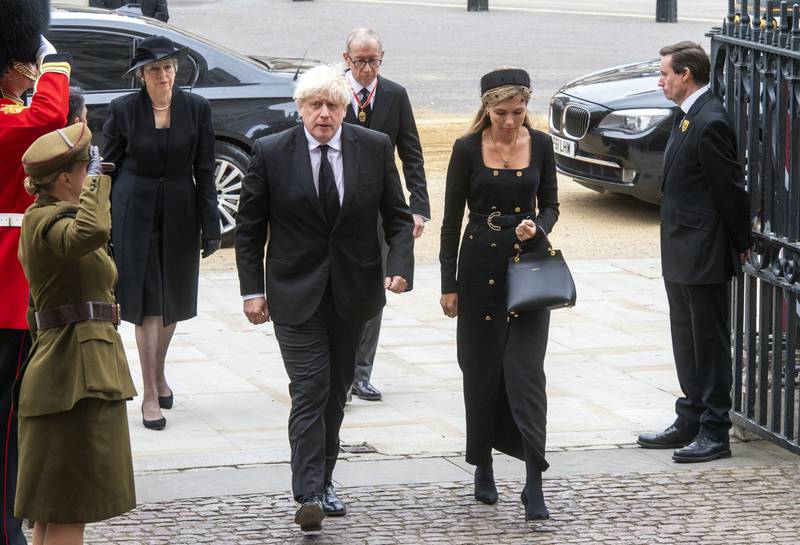 Former British prime minister Boris Johnson and his wife, Carrie Johnson, arrive at the funeral. AP