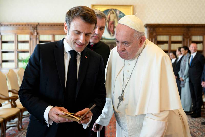 Pope Francis exchanges gifts with French President Emmanuel Macron during a private audience at the Vatican. AFP