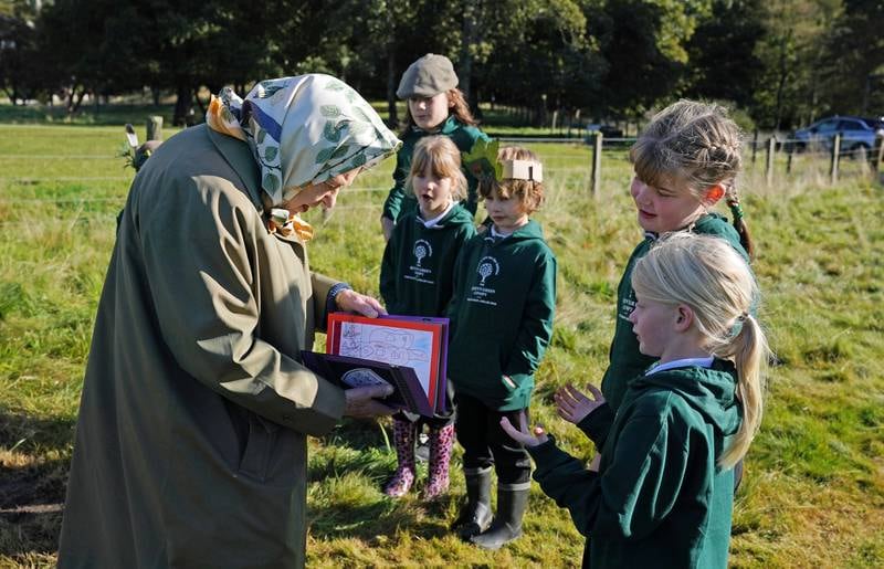 Children from Crathie Primary School present Queen Elizabeth with a card at the Balmoral Estate in October, where she and Prince Charles planted a tree to mark the start of the official planting season for the Queen's Green Canopy, near Crathie, Scotland.