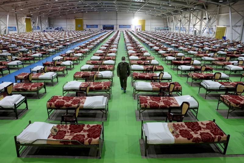 An Iranian army soldier walks past rows of beds at a temporary 2,000-bed hospital for COVID-19 coronavirus patients set up by the army at the international exhibition center in northern Tehran. AP Photo