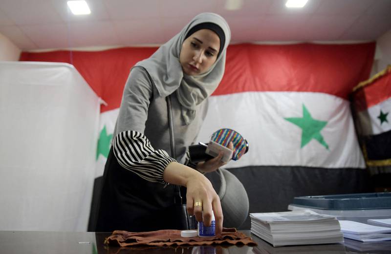A Syrian woman casts her ballot at a polling station. Mr Al Assad was competing against two obscure rivals in the May 26 election.  AFP