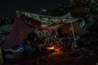 Palestinians in Gaza city sit in a tent set up on top of the ruins of a building destroyed in Israeli air strikes. Getty
