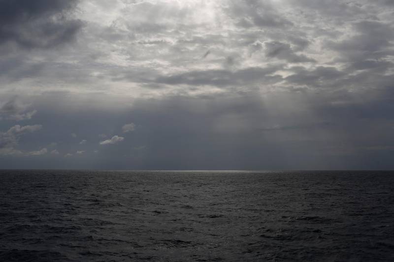 FILE -In this Sunday, Sept. 8, 2019 file photo the sun pierces the clouds over international waters north of Libya in the Mediterranean Sea.   A rubber dinghy packed with 91 migrants that set out from Libyan shores in hopes of reaching Europe has apparently gone missing in the Mediterranean, the U.N. refugee agency said Thursday, Feb. 20, 2020. The inflatable boat carrying mostly African migrants departed from al-Qarbouli, 50 kilometers (30 miles) east of the capital Tripoli on Feb. 8, said Osman Haroun, whose cousin was on board. He hasnâ€™t heard from the 27-year-old Mohamed Idris, or his 10 other friends also on the boat, since. (AP Photo/Renata Brito, File)