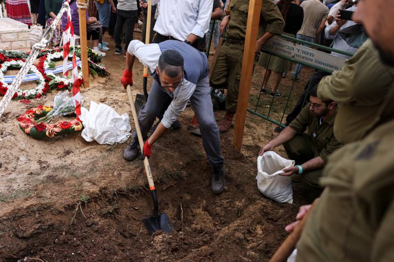 An Israeli volunteer digs a fresh grave at Mount Herzl Military Cemetery in Jerusalem, October 11, 2023. Reuters
