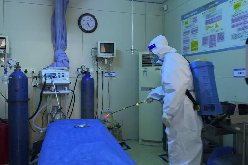 A worker disinfects a bed in the emergency department of a hospital in Baigou, Hebei province. AP 