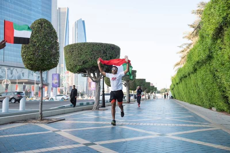 Mr Ahamed held the UAE flag as he ran through Abu Dhabi.
