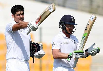 England captain Alastair Cook, left, standing next to teammate Ian Bell, waves his bat after reaching a century during Day 3 of the first Test against Pakistan at Zayed Cricket Stadium in Abu Dhabi. Hafsal Ahmed / AP Photo