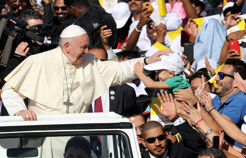 Pope Francis is greeted by a boy as he arrives to hold a Mass at Zayed Sports City. Reuters