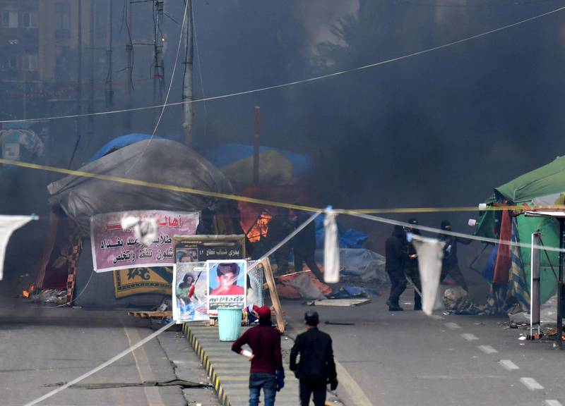 Iraqi anti-riot police forces burn the protesters' tents at Tahrir square in central Baghdad.  EPA/MURTAJA LATEEF