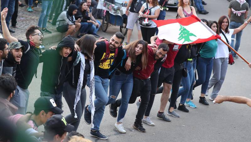 Lebanese anti-government protesters dance during a demonstration at Riad al-Solh square in the capital Beirut on the ninth day of protest against tax increases and official corruption.  AFP