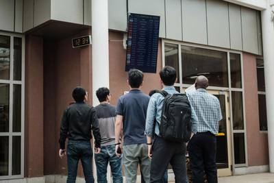 A Chinese group look at the arrival schedule board at the Jomo Kenyatta International Airport in Nairobi, Kenya. AFP