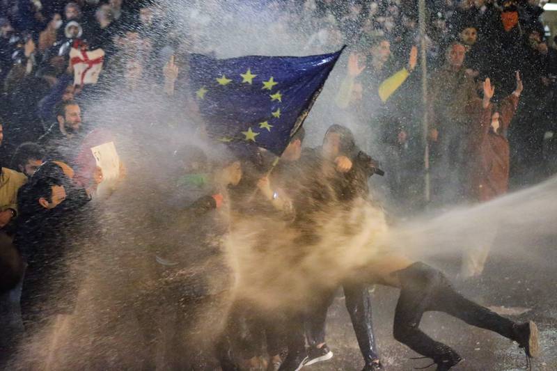 A water cannon douses protesters brandishing an EU flag in Georgia. AFP