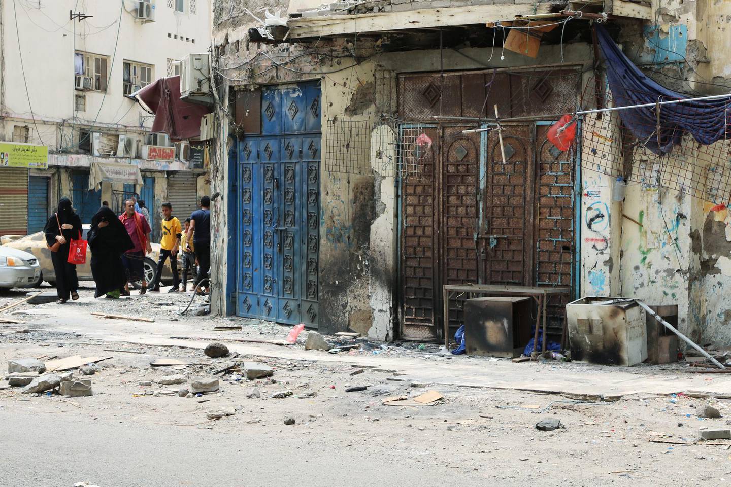 Yemeni people walk past shops damaged during clashes between separatists and government forces in Aden, Yemen August 13, 2019. REUTERS/Fawaz Salman