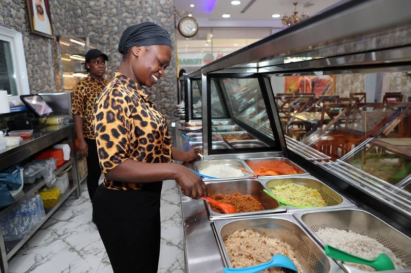 Staff with food on display at the Biggy African Restaurant in Al Nahda area in Dubai. Pawan Singh / The National