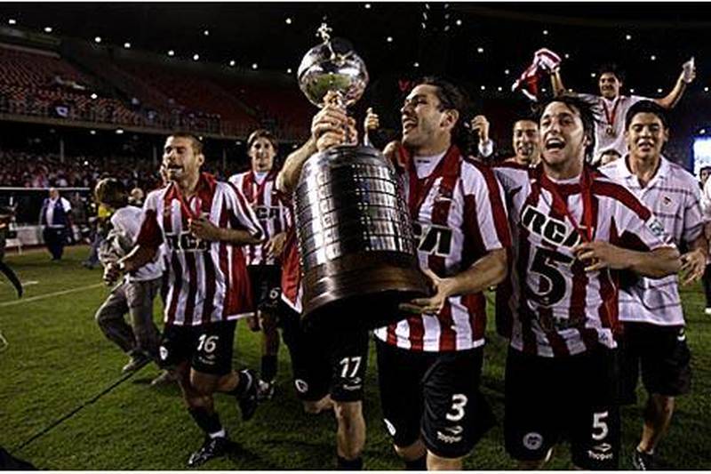 Estudiantes players celebrate with the Copa Libertadores after beating Cruzeiro 2-1 on aggregate.