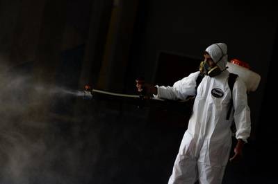 A Brazilian sanitation worker disinfects areas of a school at the Candangolância in Brasilia. Getty Images