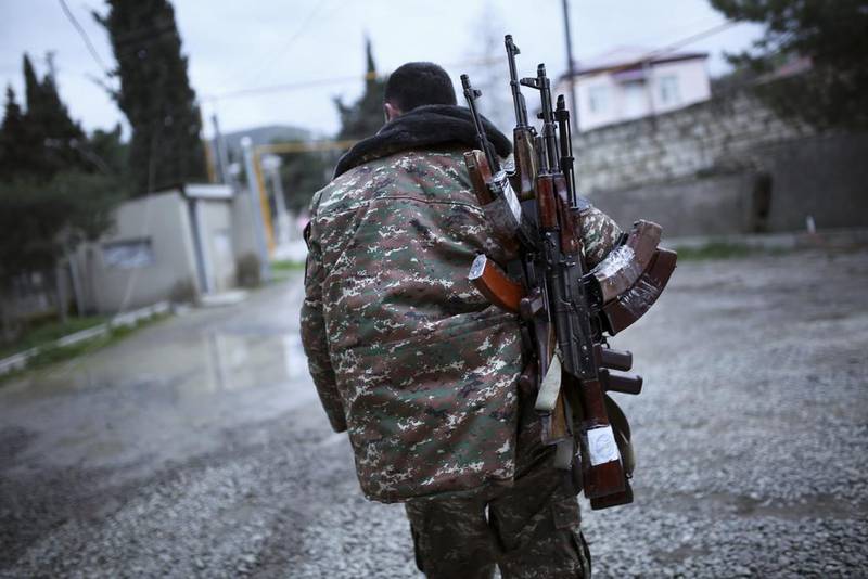 An ethnic Armenian fighter carries Kalashnikov machine guns in the separatist region of Nagorno-Karabakh, Azerbaijan. AP Photo