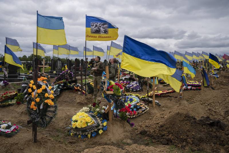 Two Ukrainian national guard soldiers pay their respects at a cemetery in Kharkiv. AP