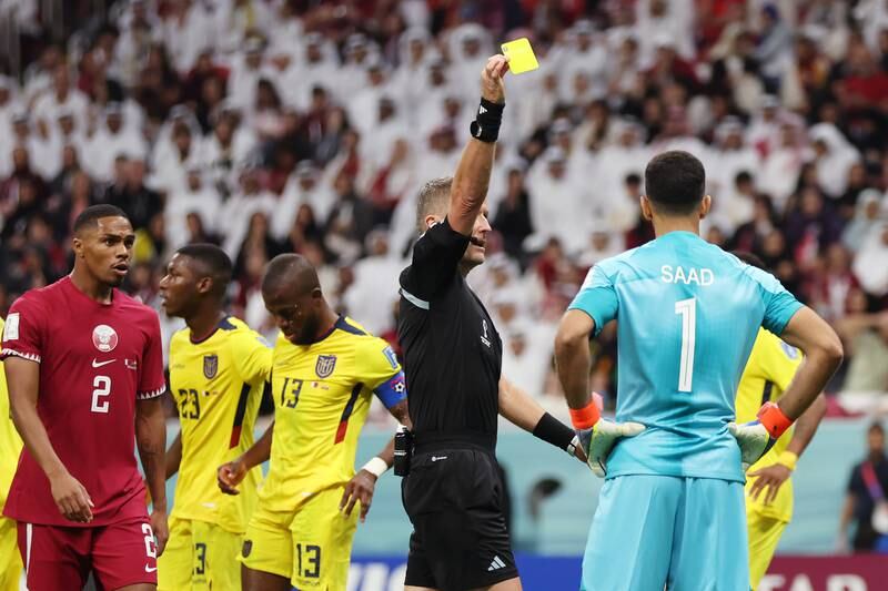 Saad Alsheeb of Qatar is shown a yellow card by referee Daniele Orsato. Getty