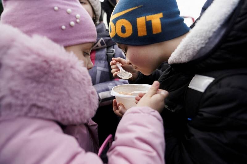 A brother and sister share a bowl of soup after they and their mother fled the Russian invasion of Ukraine and crossed the border at Medyka, Poland. Reuters
