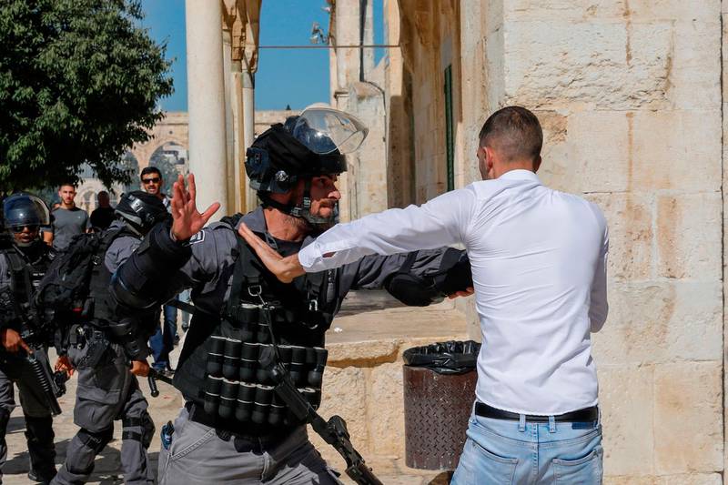 An Israeli soldier scuffles with a Palestinian at the Al Aqsa Mosque compound. AFP