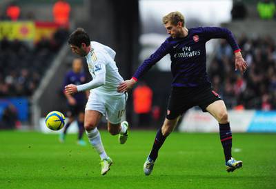 SWANSEA, WALES - JANUARY 06:  Danny Graham of Swansea City holds off Per Mertesacker of Arsenal during the FA Cup with Budweiser Third Round match between Swansea City and Arsenal at Liberty Stadium on January 6, 2013 in Swansea, Wales.  (Photo by Stu Forster/Getty Images)