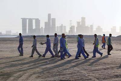 Day-shift workers pass the incoming night-shift workers at the shift change-over at the Saadiyat Construction Village. Silvia Razgova / The National