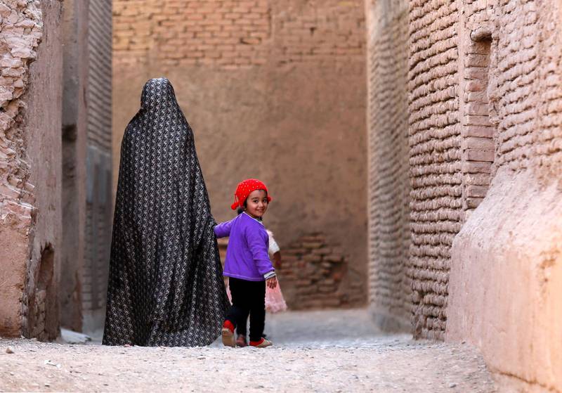 An Afghan woman walks with a child in the old city of Herat province, Afghanistan October 15, 2018. REUTERS/Mohammad Ismail