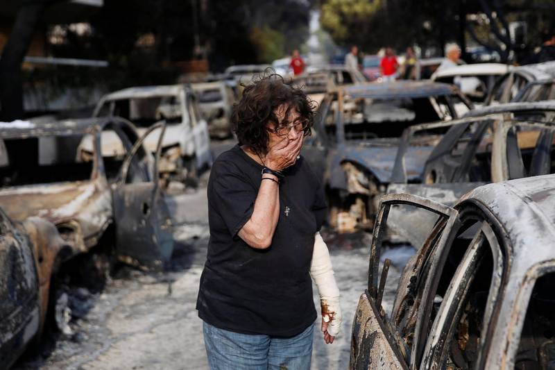A woman reacts as she tries to find her dog, following a wildfire at the village of Mati. Reuters