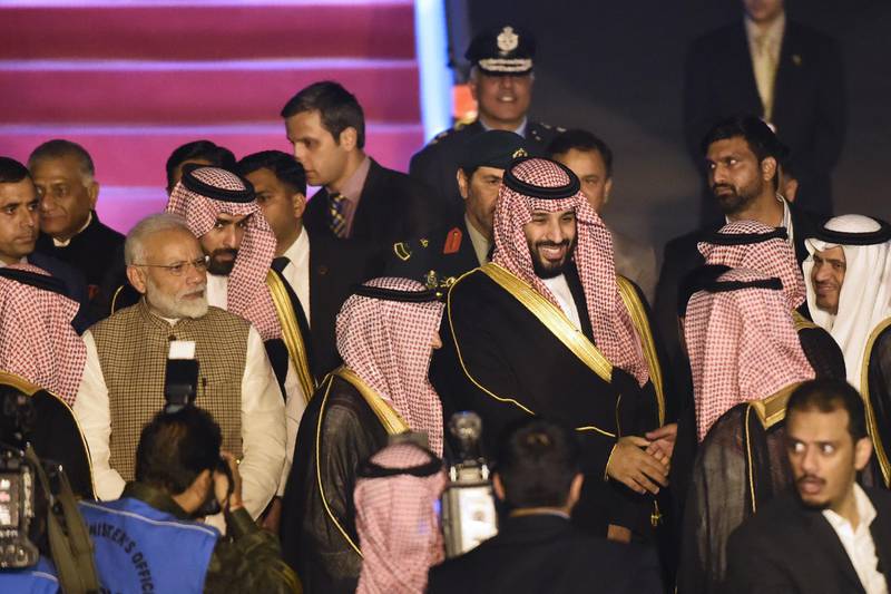 Saudi Crown Prince Mohammed Bin Salman stands next to Indian Prime Minister Narendra Modi upon arriving at the airport in New Delhi. AFP
