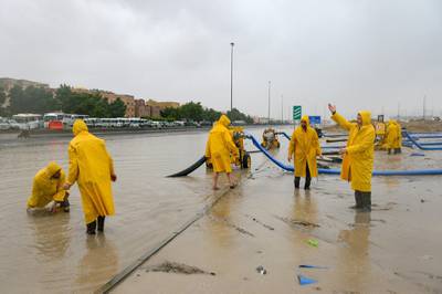 Municipal workers clear the water on roads after heavy rain in Kuwait City. EPA