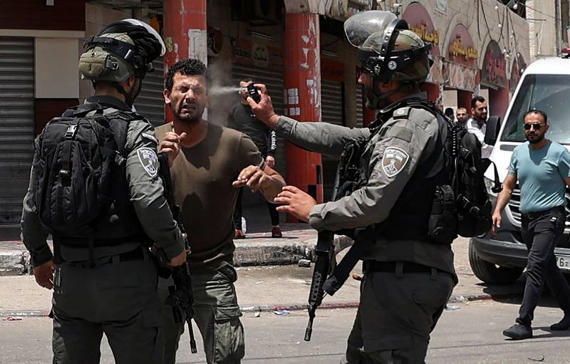 An Israeli border guard sprays pepper gas in the face of a Palestinian protester in the West Bank town of Hauwara. AFP
