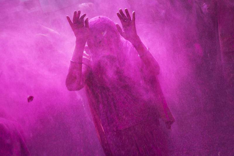 A widow raises her hands as others throw coloured powder on her during celebrations marking Holi at the Meera Sahabhagini Widow Ashram in Vrindavan, India, on March 3. Bernat Armangue / AP Photo