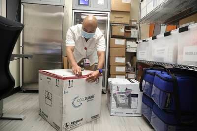 A pharmacist opens a freezer transport box containing the Jynneos vaccine for monkeypox in San Francisco. AP