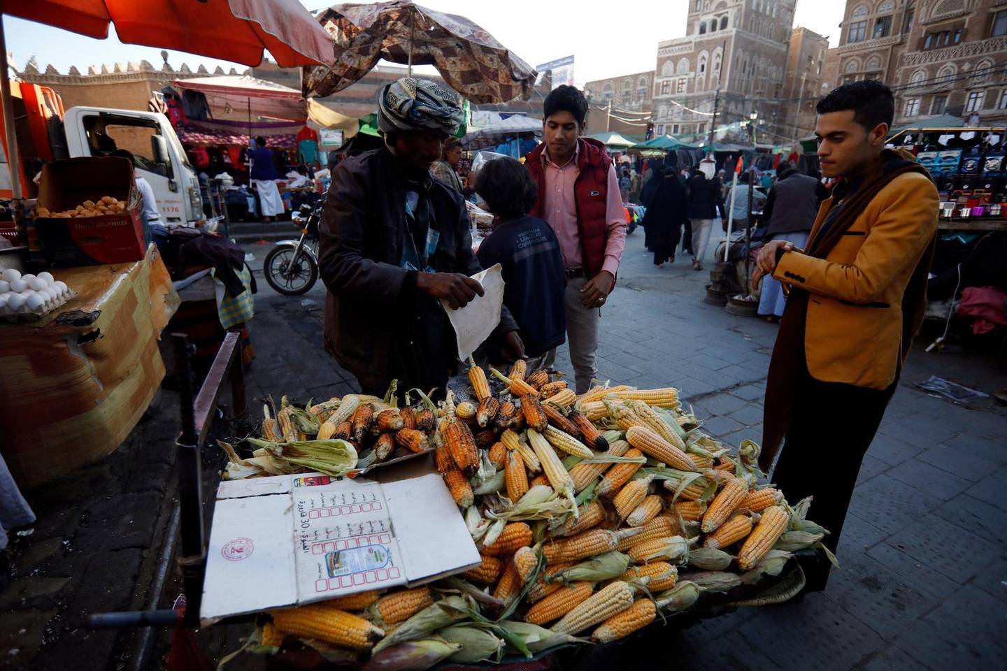 epa08136659 A Yemeni vendor (L) displays grilled maize for sale at a market in the old quarter of Sanaa, Yemen, 17 January 2020. According to reports, UN special envoy to Yemen Martin Griffiths will head to the Houthi-held capital Sanaa next week as part of his ongoing diplomatic efforts to revive the stumbling political process between Yemen's warring parties, hoping the belligerents could resume peace talks to end the prolonged war, in 2020.  EPA/YAHYA ARHAB