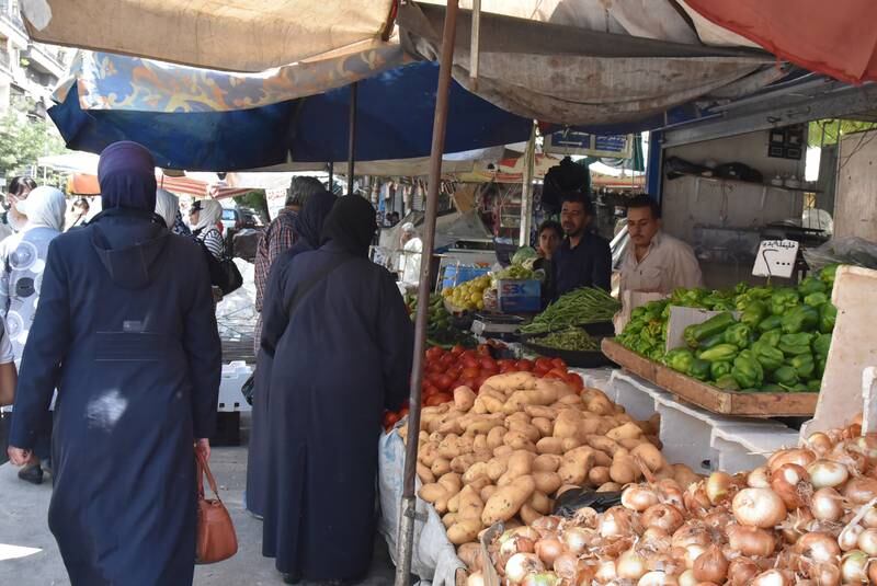 Syrians shop for vegetables at a market in Damascus on Sunday July 11, hours after Syrian President Bashar Al Assad issued a legislative decree granting civil servants and military members a 50 per cent pay rise. The decision comes a day after the government raised the price of fuel by more than 50 per cent for the third time this year. EPA