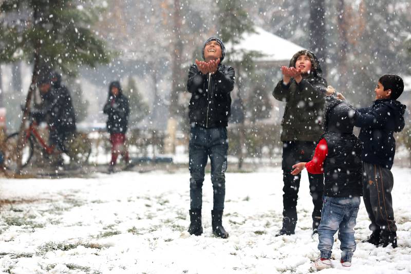Boys play in a park during snowfall in Kabul. AFP